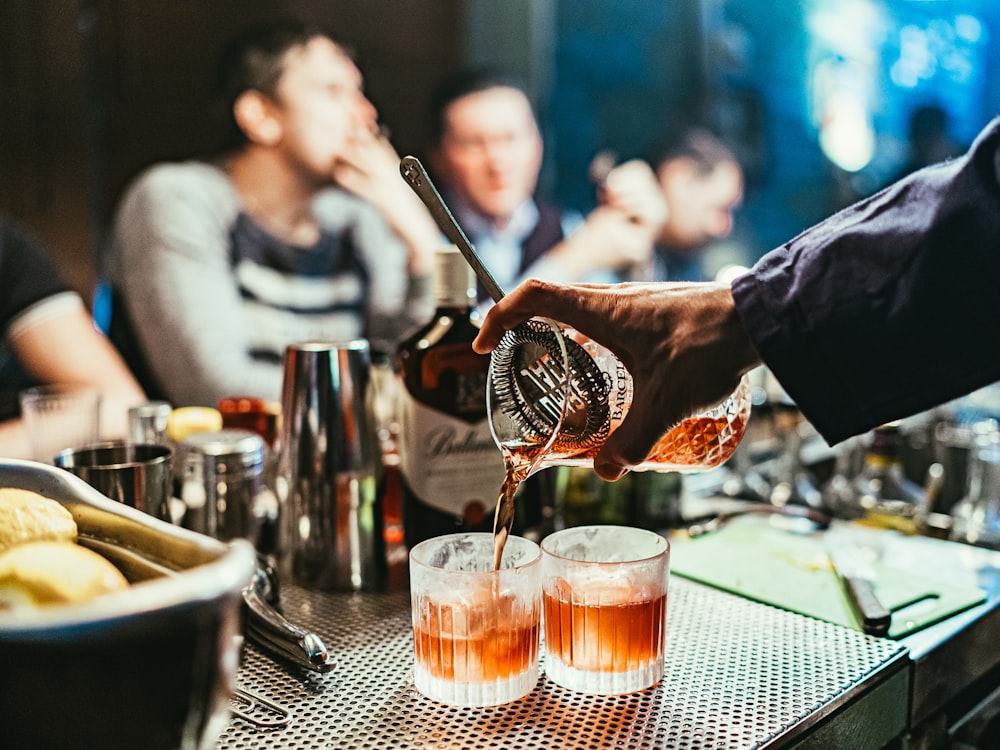 A bartender pouring cocktails at a styled bar