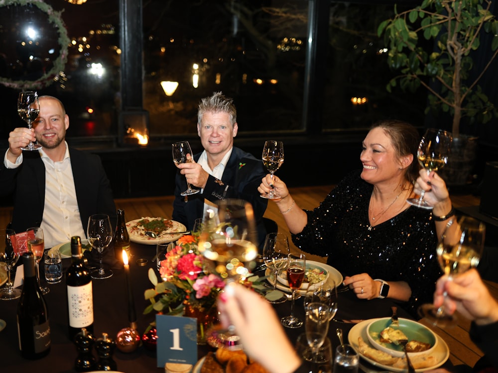 Guests toasting with drinks around a table at a party
