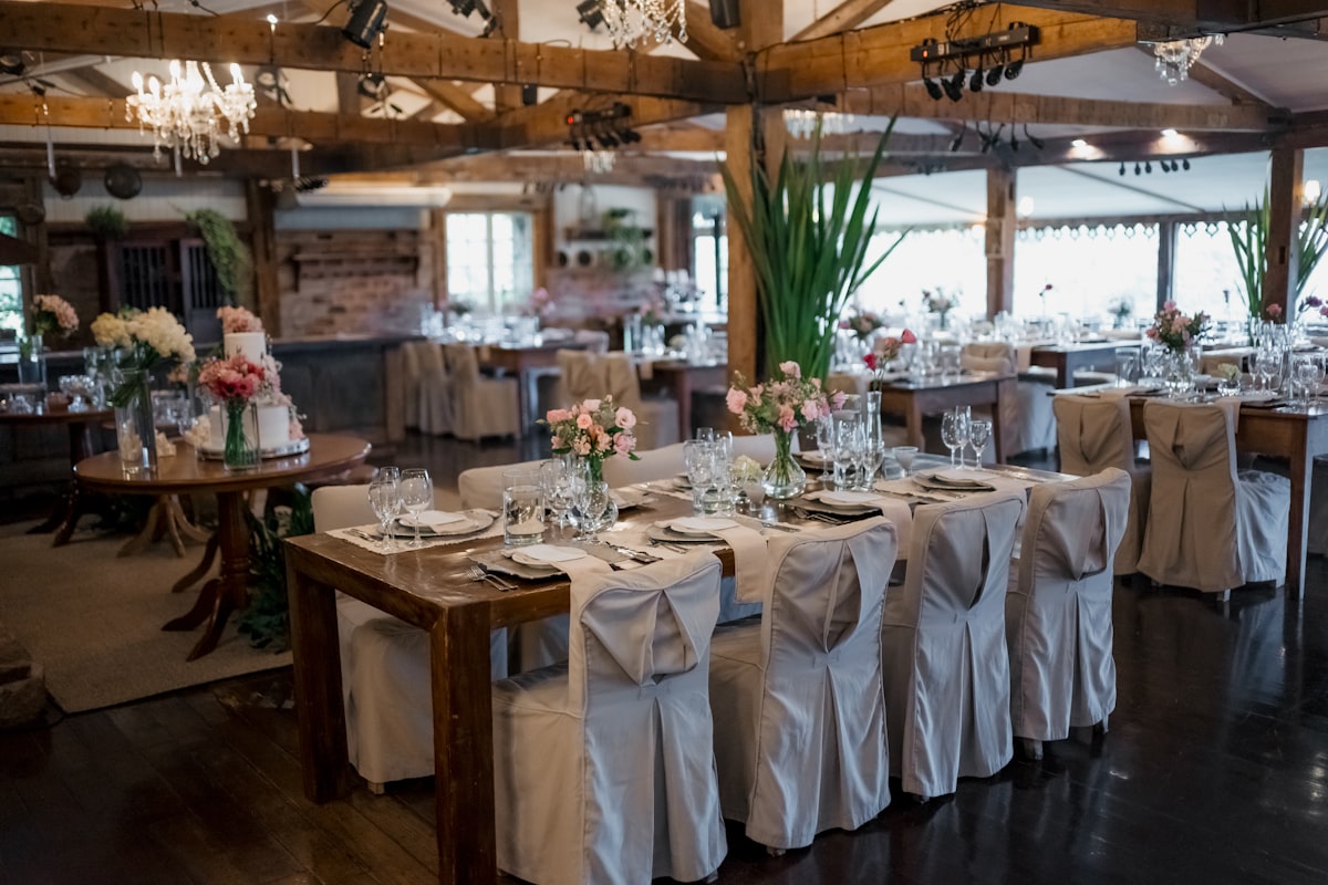 A reception room of set tables and draped chairs before guests arrive
