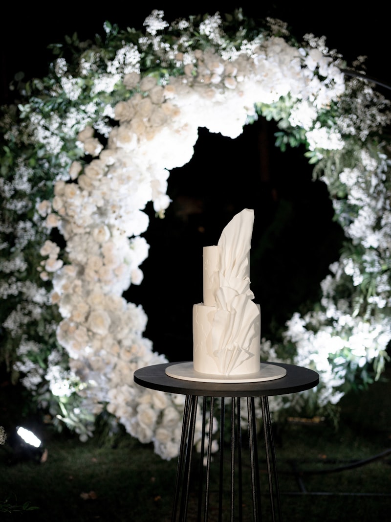 A wedding cake displayed inside a ring of white florals
