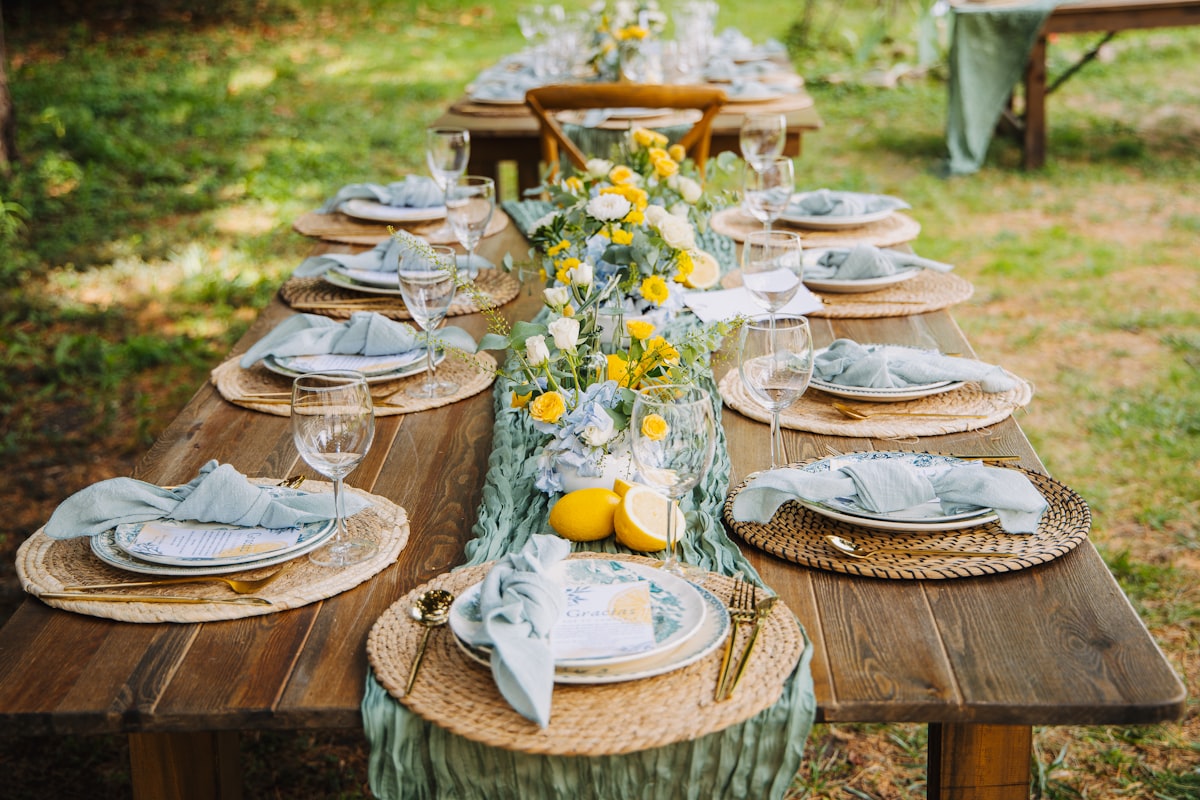 A rustic wedding table set with place settings, lemons and candles