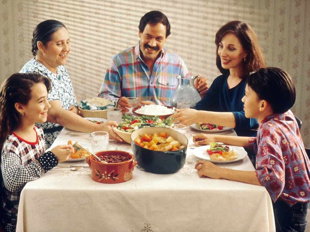 A family gathered around a table sharing a home-catered meal