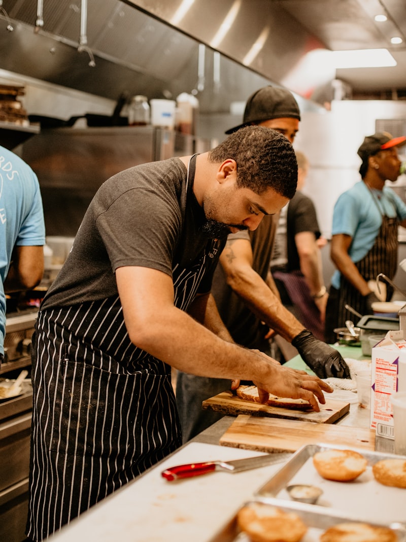 Kitchen staff prepping side by side along a counter