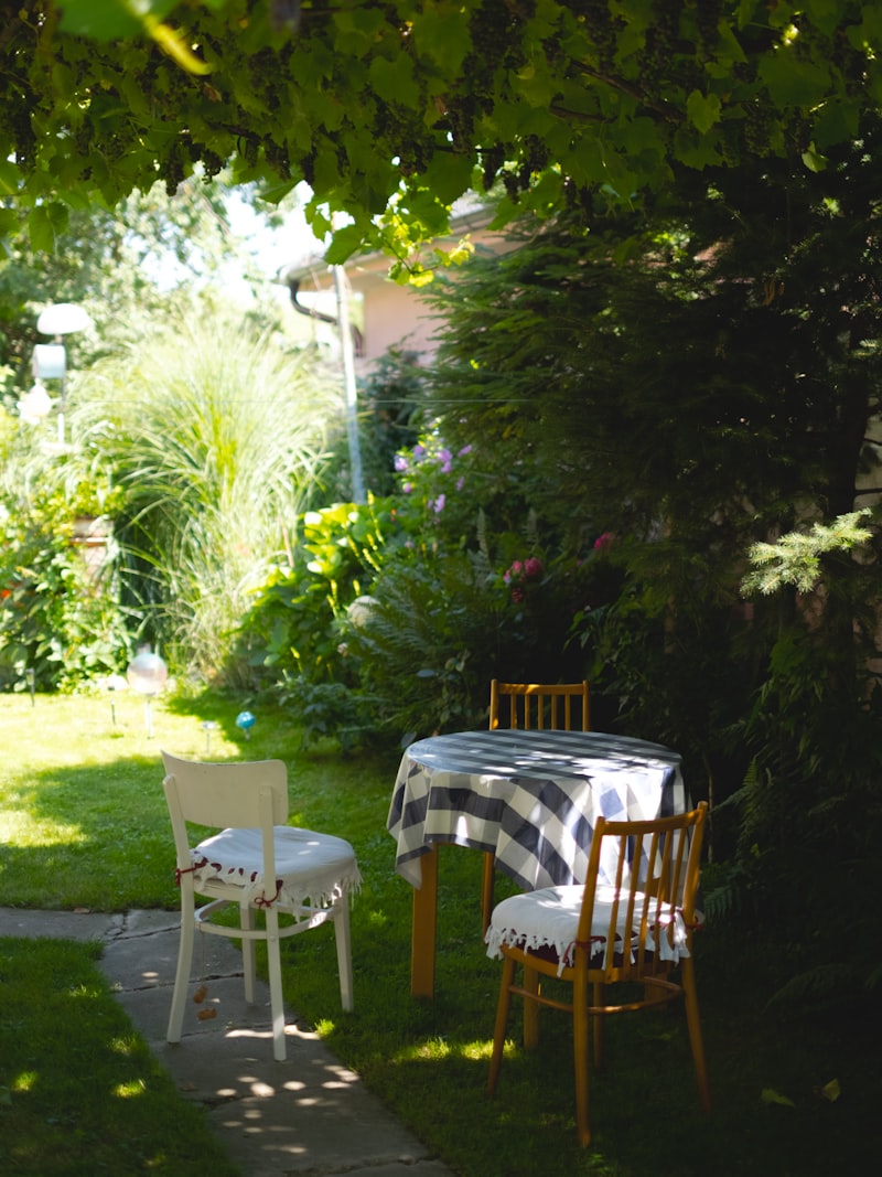 A table set for a private party in a leafy backyard garden