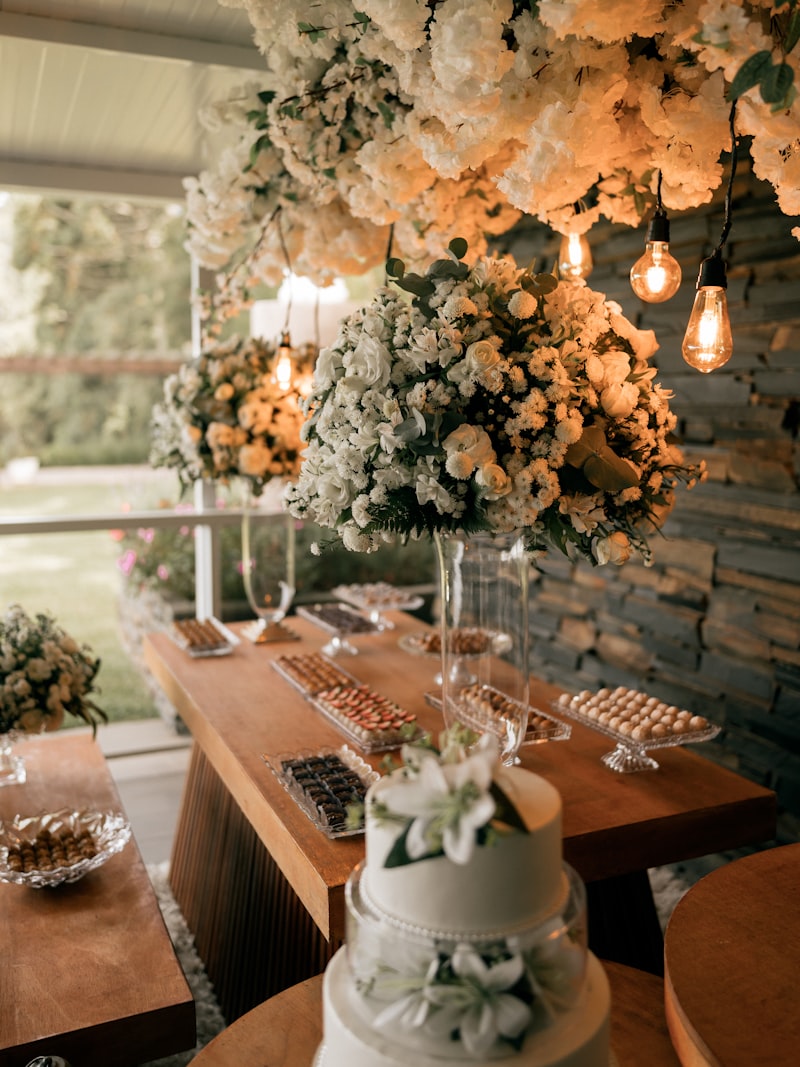 A dessert and cake table styled with florals and candlelight